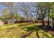 Expansive backyard featuring a large lawn, storage shed, mature trees, and a wooden fence at 43 Lott Se Ave, Marietta, GA 30067