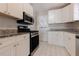 Updated kitchen with stainless steel appliances, granite countertops, and white cabinetry at 43 Lott Se Ave, Marietta, GA 30067