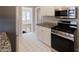 Well-lit kitchen featuring white tile flooring, stainless steel appliances, and granite countertops at 43 Lott Se Ave, Marietta, GA 30067