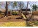 Backyard with a wooden playground structure, including swings and a slide, on a mulch surface at 43 Lott Se Ave, Marietta, GA 30067