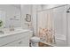 Clean bathroom featuring a white vanity, a matching toilet, and a shower-tub combination with a decorative floral curtain at 13 Oakside Nw Ct, Cartersville, GA 30121