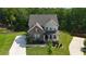 Aerial view showcases a charming two-story brick home with a well-kept lawn and inviting front porch at 13 Oakside Nw Ct, Cartersville, GA 30121