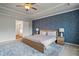 Serene main bedroom featuring a tray ceiling, stylish wallpaper, and soft lighting at 13 Oakside Nw Ct, Cartersville, GA 30121