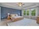 Serene main bedroom featuring a tray ceiling, a feature wall, large windows, and ample natural light at 13 Oakside Nw Ct, Cartersville, GA 30121