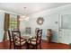Formal dining room with a glass table, decorative lighting, and wood floors at 1608 Drakes Dr, Jonesboro, GA 30236