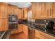 Close up on a kitchen with wood cabinets, black countertops, and stainless steel appliances at 1608 Drakes Dr, Jonesboro, GA 30236