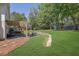Lush backyard with a patio, firepit area, mature trees, and play set visible in the distance at 3935 Manor House Dr, Marietta, GA 30062