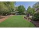 Spacious backyard with mature trees, play set, and manicured lawn, offering ample space for outdoor activities at 3935 Manor House Dr, Marietta, GA 30062