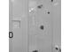 All-white tiled walk in shower with glass door and black hardware at 3935 Manor House Dr, Marietta, GA 30062