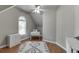 Attic space with a window, sewing machine and plush white rug over hardwood floors at 1315 Chattahoochee Run Dr, Suwanee, GA 30024
