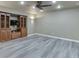 Finished basement featuring gray wood-look flooring, ceiling fan and custom built-in shelving at 1315 Chattahoochee Run Dr, Suwanee, GA 30024
