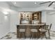 Basement wet bar with granite counter tops, wooden cabinets and upholstered bar stools at 1315 Chattahoochee Run Dr, Suwanee, GA 30024
