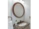 Bathroom vanity featuring a granite countertop, bronze faucet, and decorative bronze mirror at 1315 Chattahoochee Run Dr, Suwanee, GA 30024
