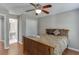 Bedroom with wood floors, ceiling fan and view into bathroom at 1315 Chattahoochee Run Dr, Suwanee, GA 30024