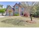 Beautiful two-story brick home with lush green lawn, mature tree, and elegant architectural details at 1315 Chattahoochee Run Dr, Suwanee, GA 30024