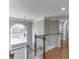 Upstairs hallway featuring wood floors, white banister, and arched window at 1315 Chattahoochee Run Dr, Suwanee, GA 30024
