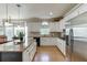 Modern kitchen with stainless steel refrigerator, white cabinets, granite countertops, and natural light at 1315 Chattahoochee Run Dr, Suwanee, GA 30024