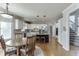 Bright kitchen with white cabinets, stainless appliances, dark island, and a wooden dining table at 1315 Chattahoochee Run Dr, Suwanee, GA 30024
