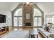 Living room featuring a stone fireplace, vaulted ceiling, large windows, and light gray walls at 1315 Chattahoochee Run Dr, Suwanee, GA 30024