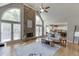 Open-concept living room with a stone fireplace, windows, and view into kitchen and eating area at 1315 Chattahoochee Run Dr, Suwanee, GA 30024