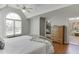Bright main bedroom features hardwood floors, a ceiling fan, and large arched window at 1315 Chattahoochee Run Dr, Suwanee, GA 30024