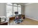 Bright home office featuring hardwood floors, a desk setup, and large arched windows with natural light at 1315 Chattahoochee Run Dr, Suwanee, GA 30024