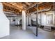 Open basement featuring painted concrete floors, support beams, and staircase to upper level at 1900 Ridgewood Ne Dr, Atlanta, GA 30307