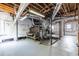 Spacious unfinished basement with exposed ductwork, wood beams, and painted concrete floor at 1900 Ridgewood Ne Dr, Atlanta, GA 30307