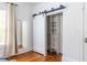 An open closet with custom shelving provides efficient storage, complemented by a barn door and full-length mirror at 1900 Ridgewood Ne Dr, Atlanta, GA 30307