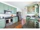 Well-lit kitchen showcasing stainless steel appliances, green cabinetry, and dark countertops at 1900 Ridgewood Ne Dr, Atlanta, GA 30307