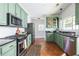 Bright kitchen featuring green cabinets, granite counters, stainless steel appliances, and brick flooring at 1900 Ridgewood Ne Dr, Atlanta, GA 30307