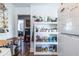 Open kitchen featuring a refrigerator, white shelving and connections to other rooms at 1900 Ridgewood Ne Dr, Atlanta, GA 30307
