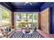 Inviting sunroom with exposed brick, painted ceiling, and sliding windows overlooking the neighborhood at 1900 Ridgewood Ne Dr, Atlanta, GA 30307