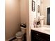 Bathroom features a toilet with a lid cover and vanity with decorations and dark wood cabinets at 375 Madison Grace Ave, Mcdonough, GA 30252