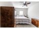 Bedroom offers a ceiling fan, queen bed with striped bedding, and dark wood dressers for ample storage at 375 Madison Grace Ave, Mcdonough, GA 30252
