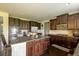 Contemporary kitchen with a granite island, stainless steel appliances, and dark wood cabinets at 375 Madison Grace Ave, Mcdonough, GA 30252