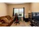 This living room boasts a comfortable couch, television, and mini refrigerator near a window at 375 Madison Grace Ave, Mcdonough, GA 30252