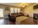Well-lit living room with a fireplace, large windows, and a sizable brown leather sectional couch at 375 Madison Grace Ave, Mcdonough, GA 30252