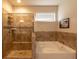 Main bathroom featuring a tiled shower, soaking tub, and a decorative accent tile at 375 Madison Grace Ave, Mcdonough, GA 30252