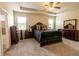 Well-lit main bedroom featuring a tray ceiling, ceiling fan, carpeted floor, and traditional-style furniture at 375 Madison Grace Ave, Mcdonough, GA 30252