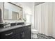 Stylish bathroom featuring a dark vanity with elegant fixtures, a patterned floor, and a shower with a curtain at 588 Bismark Ne Rd, Atlanta, GA 30324