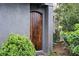 Close-up of a beautiful wood front door framed by lush green landscaping at 588 Bismark Ne Rd, Atlanta, GA 30324