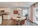 Bright dining area features a stylish light fixture, round wood table, and view to the patio at 6550 Lantana Village Way, Cumming, GA 30028
