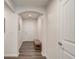 A clean foyer featuring wood floors, a small bench, white walls, and a door leading to additional rooms at 6550 Lantana Village Way, Cumming, GA 30028