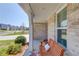 Inviting front porch with a wooden bench, white pillars, and lush landscaping; perfect for relaxing outdoors at 6550 Lantana Village Way, Cumming, GA 30028