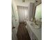 Well-lit bathroom featuring a vanity, a shower with curtains, and a storage cabinet at 6695 Cedar Hurst Trl, Atlanta, GA 30349