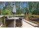 View of the deck with table, umbrella, and chair set surrounded by trees at 1050 Willeo Ct, Marietta, GA 30068