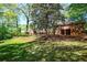 View of the house exterior, featuring an expansive backyard with a shed and partially covered patio area at 1400 Hidden Circle Dr, Sugar Hill, GA 30518