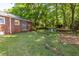 Expansive backyard with brick home, mature trees, and outdoor dining area at 1740 Fairbanks Sw St, Atlanta, GA 30310