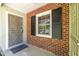 Close-up of a brick-clad front porch with an ornate security door and black shutters, blending classic charm at 1740 Fairbanks Sw St, Atlanta, GA 30310